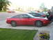 1990 Nissan 240SX - Red 1990 Nissan 240SX coupe parked on a driveway next to other vehicles.