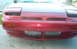 1990 Nissan 240SX - The front of a red Nissan 240SX is shown, pop-up headlights and an intercooler.