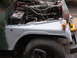 1973 Jeep CJ5 - The front fender and engine bay of a 1973 Jeep CJ5 are shown, with the hood open.