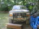1986 Ford Bronco - Front view of a 1986 Ford Bronco, showing its grille, winch, and a website sticker on the windshield.