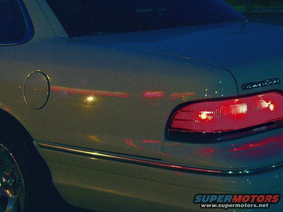 The neon signs reflecting off the paint. Note the dark blue twilight sky reflection on the trunk lid.