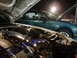 1993 Ford Probe - Two cars are parked with their hoods open, revealing engine bays and components under artificial lighting.