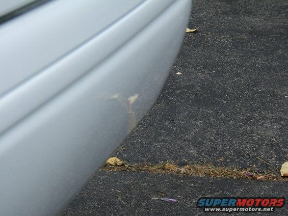 close-up of a silver car's rear bumper with some scuffs