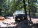 1988 Ford Bronco - White Ford Bronco navigates a challenging off-road course with steep inclines and large rocks.