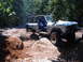1988 Ford Bronco - This classic Ford Bronco is tackling a challenging off-road trail with large rocks and dirt mounds.