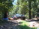 1988 Ford Bronco - Off-roading Jeep Wrangler navigates a challenging dirt trail with spectators.