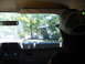 1988 Ford Bronco - View from inside a vehicle looking out at another off-road vehicle navigating a wooded trail.