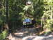 1988 Ford Bronco - This off-road SUV navigates a wooded trail, with another vehicle seen further up the incline.