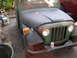 1973 Jeep CJ5 - Front view of a 1973 Jeep CJ5 with green and red paint, parked outdoors.
