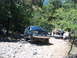 1988 Ford Bronco - This green SUV navigates a rough, rocky path with another truck visible in the background.