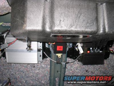 Car interior with silver amplifier, black JBL amplifier, and red warning label