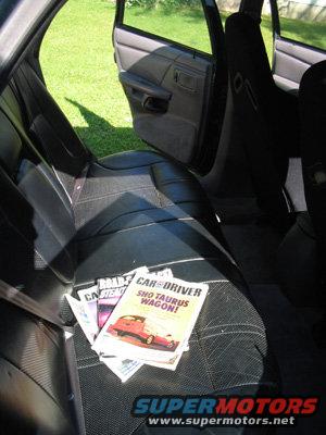 Interior view of a car showing black seats with magazines on them, including a Car and Driver issue about a Taurus wagon