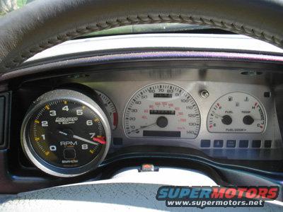 Dashboard with aftermarket tachometer and stock speedometer, fuel, and temperature gauges. The speedometer reads up to 140 mph