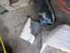 1994 Ford Probe - Car parts, including a seat and a damaged bumper, are laid out on a concrete floor with fiberglass matting.
