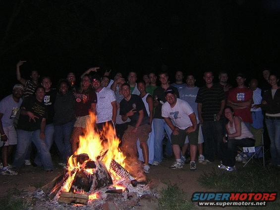 Group of people gathered around a bonfire at night