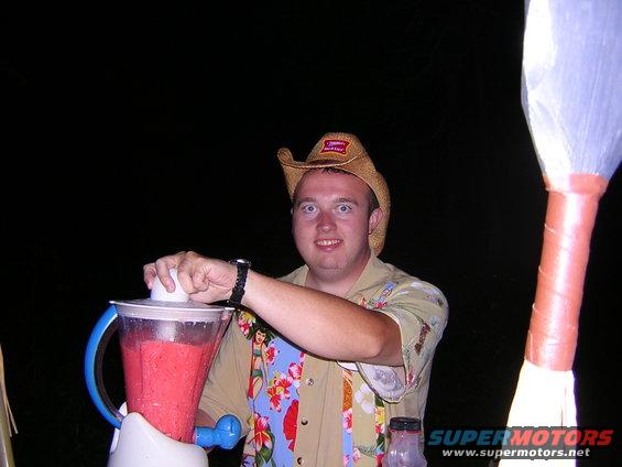 Man in cowboy hat making a strawberry smoothie in a blender