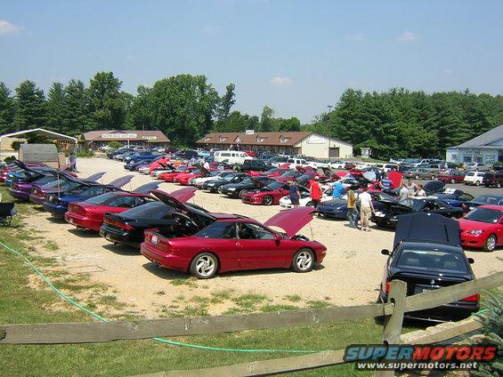 Red 1993 Ford Probe with hood open, parked in a lot with many other cars