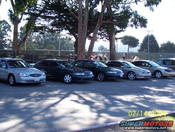 Silver 1996 Ford Taurus sedan parked in a line with other cars