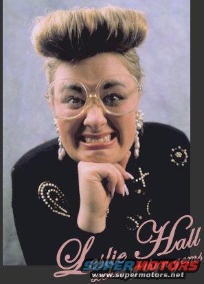 woman with big hair, large glasses, and pearl earrings