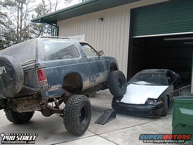 Lifted 1992 Chevrolet S10 Blazer rear view with spare tire and another car