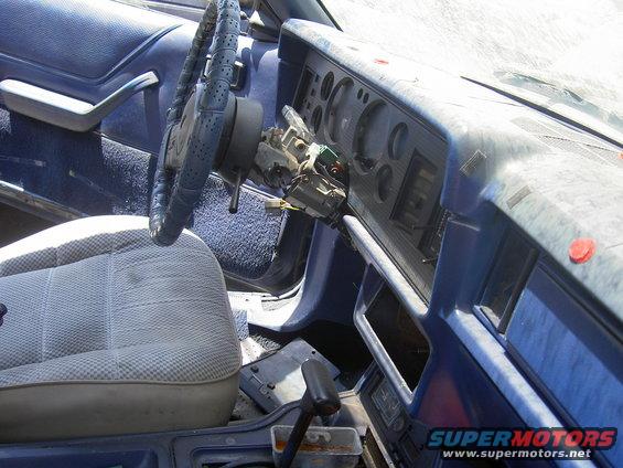 Interior of a 1982 Ford Mustang showing a blue dashboard, steering wheel, and seat