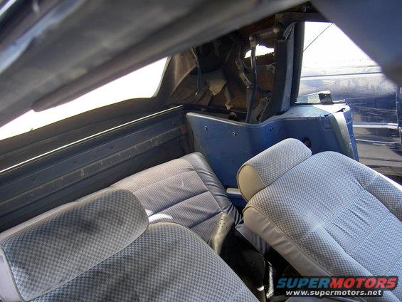 Interior of a blue convertible showing seats and top mechanism