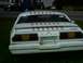 1978 Ford Mustang II - The rear of a white 1978 Ford Mustang II is shown with a striped decal on the trunk and an American flag sticker on the rear window.