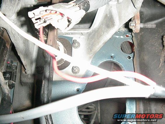Close-up of wiring harness and metal brackets inside a vehicle
