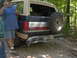 1978 Ford Bronco - A man stands next to a Ford Bronco parked on a dirt road in a wooded area.
