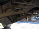 1978 Ford Bronco - Undercarriage detail of a vehicle, with another vehicle partially visible in the background.