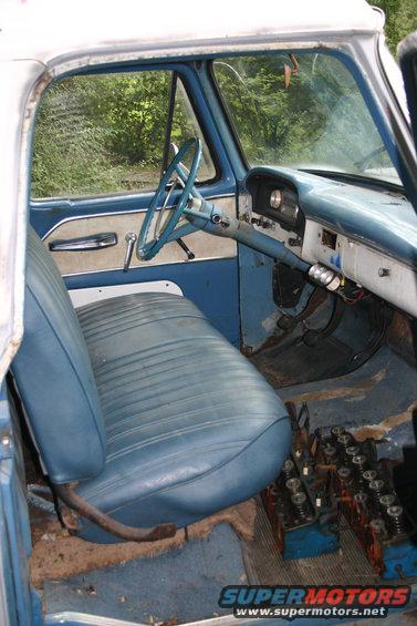 blue vinyl bench seat, dashboard, and steering wheel of an old truck