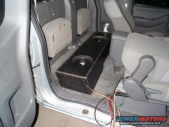 Pickup truck interior showing a custom subwoofer box installed behind the front seats