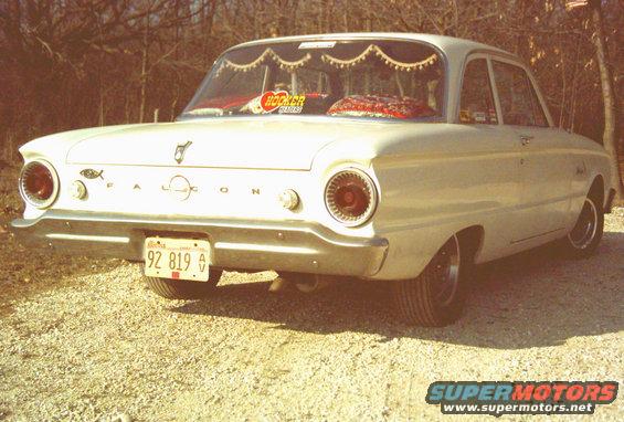 White 1962 Ford Falcon sedan, rear view, parked on gravel
