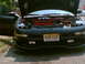 1997 Ford Probe - A black car with its hood open is parked outside, revealing its engine and red accents.
