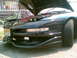 1997 Ford Probe - Front view of a black car with its hood open, revealing engine components. The license plate reads KRM-55B.