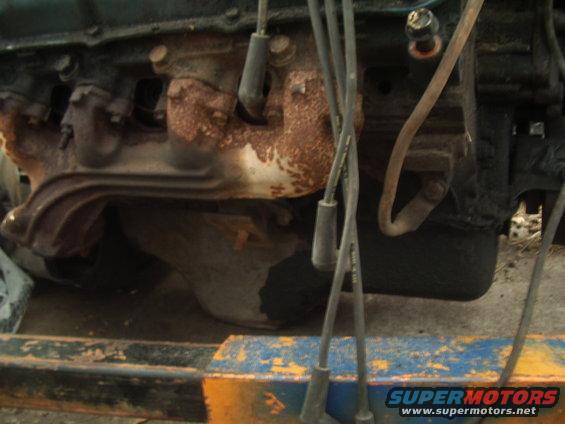 close-up of rusty exhaust manifold and spark plug wires