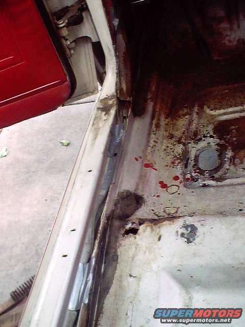 1966 Ford Fairlane interior floor pan and door jamb showing rust and damage