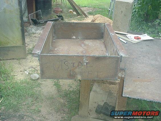 Metal box with "OUTSIDE LEFT" written on it, welded construction, outdoors
