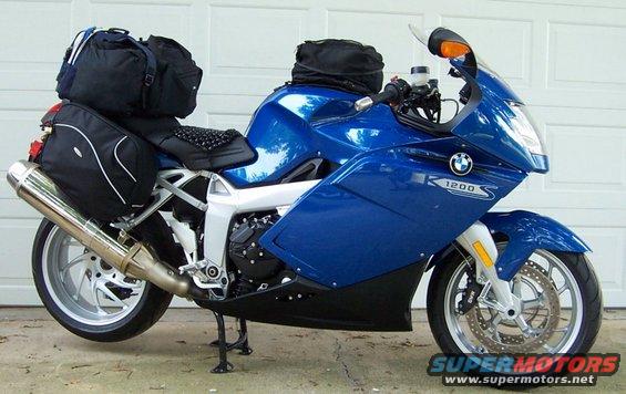 Blue 2005 BMW R1200CA ABS motorcycle with saddlebags and a top bag, parked in front of a garage door