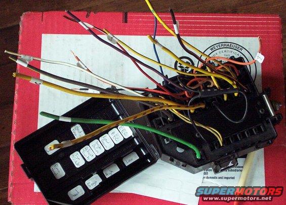 Wires and labels on an open automotive fuse box