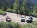 2000 Jeep Cherokee - Several SUVs, including a red Jeep Cherokee, are parked on a dirt road in a mountainous, wooded area.