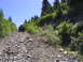 2000 Jeep Cherokee - An SUV navigates a challenging, rocky path on a mountain trail under a clear blue sky.