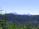 2000 Jeep Cherokee - A scenic view of a mountain range under a clear blue sky, with evergreen trees in the foreground.