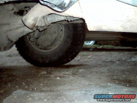 Undercarriage view showing the rear wheel and suspension components of a vehicle