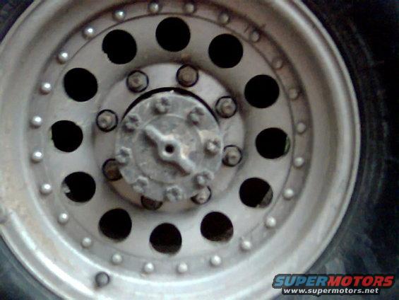 Close-up of a silver wheel with multiple holes and a hub