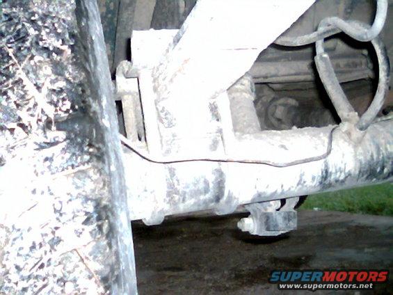Close-up of rear axle, leaf springs, and brake lines on a vehicle