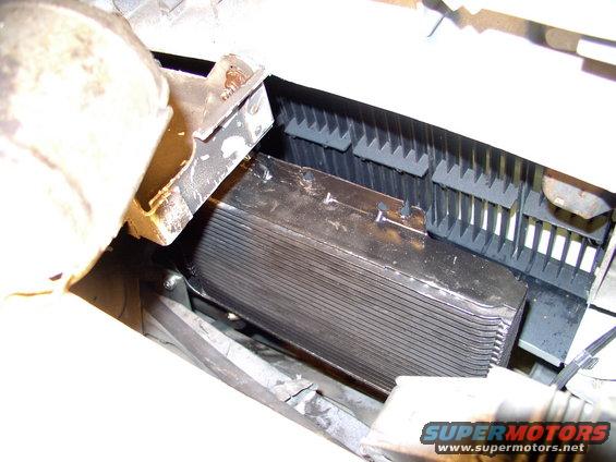 img_0096.jpg Here's the Supercooler mounted between the grill and the AC condensor. Beat two angle brackets from 90 degrees to about 135 degrees and bolted it left and right at the bottom(see bolts on lower left). Secured the top left with a straight strap bolted between that front nose and brace (see nut at top).
