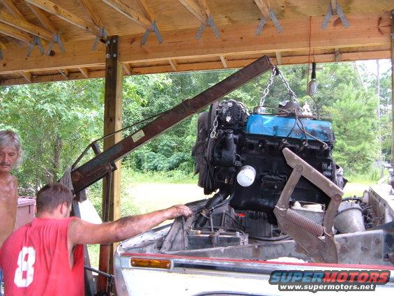 Engine being lowered by a crane into a vehicle's engine bay