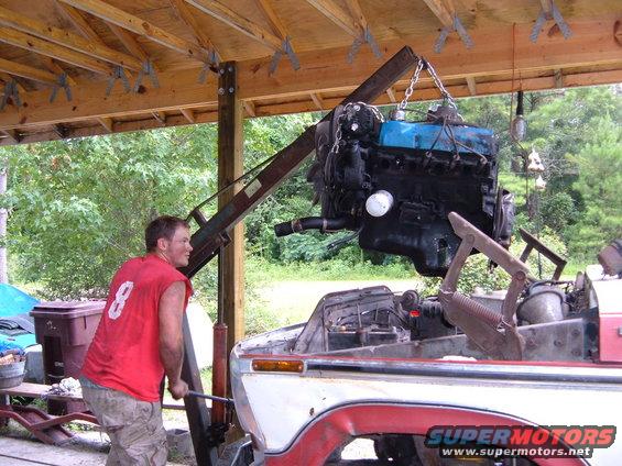 Engine being lifted into a truck bed with a crane