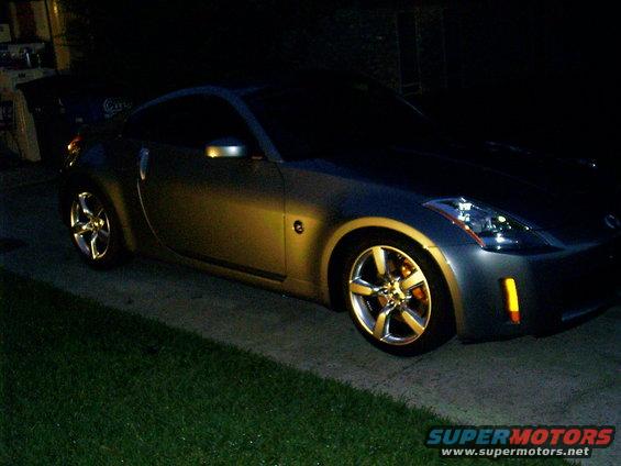 Gray coupe with chrome wheels parked at night